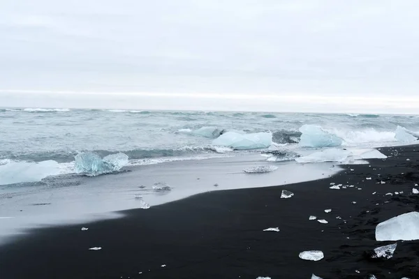 Een Schilderachtig Uitzicht Ijs Zwart Zandstrand Tegen Zee Golven Een — Stockfoto