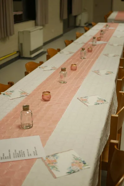 一张长长的桌子 桌子上有粉色和白色的长跑者和蜡烛 — 图库照片