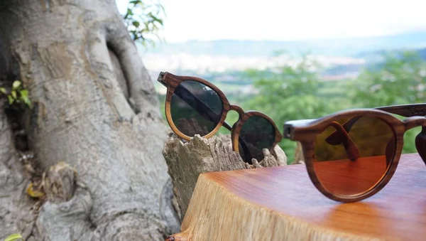 Zwei Sonnenbrillen Auf Einer Holzoberfläche Vor Verschwommenem Hintergrund — Stockfoto