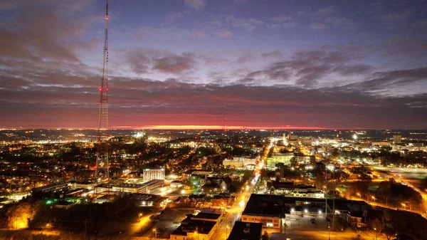 Aydınlatılmış Şehrin Havadan Çekilmiş Bir Görüntüsü Arkasında Pembe Günbatımı Olan — Stok fotoğraf