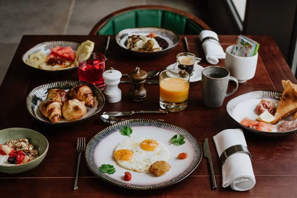 Läcker Frukost Ett Träbord Med Ägg Croissanter Havregryn Och Sallad — Stockfoto