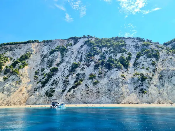 岩の多い島の隣の海の表面にあるクルーズ船 — ストック写真