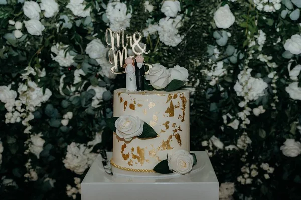 gold and cream wedding cake with mr and mrs cake topper