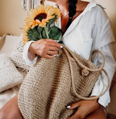 Güzel bir kadın eli manzarası. İçinde ayçiçekleri olan saman torbası.