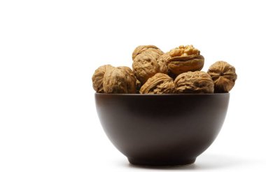 walnuts in a brown bowl isolated on a white background