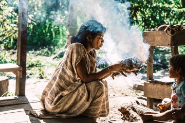 Peru Amazon nehri boyunca ateş yakan genç bir Amazon kadınının yakın çekimi.