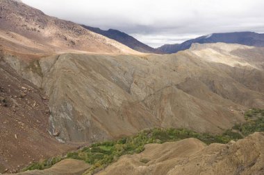 Fas 'ta bulutlu gökyüzünün altında, altında yeşil ağaçlar olan büyük dağlardan oluşan güzel bir manzara.