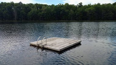 Bir gölün yüzeyindeki yüzen ahşap rıhtımın manzarası.