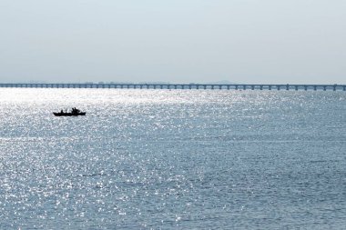 Arka planda köprüsü olan güzel bir deniz manzarası..