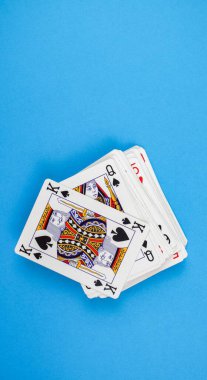 Mavi arkaplanda izole edilmiş bir iskambil destesinin dikey görüntüsü