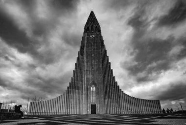 Reykjavik, İzlanda 'da bulutlu bir gökyüzünün altında Hallgrimskirkja' nın gri tonlu bir görüntüsü.