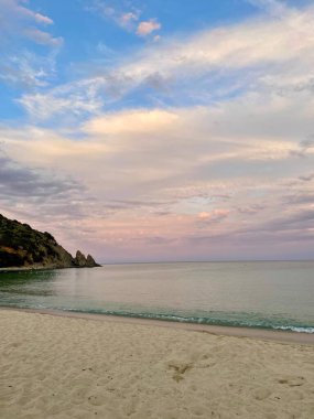 Gün batımında güzel bir sahil ve orman manzarası.