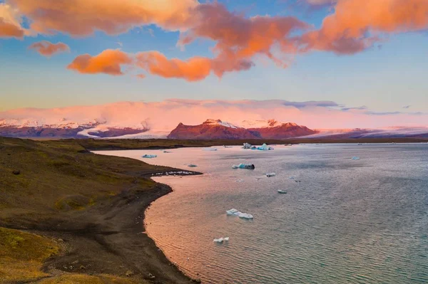 在冰岛一个令人叹为观止的落日中 约库尔沙隆湖上漂浮着一片冰山的景观 — 图库照片