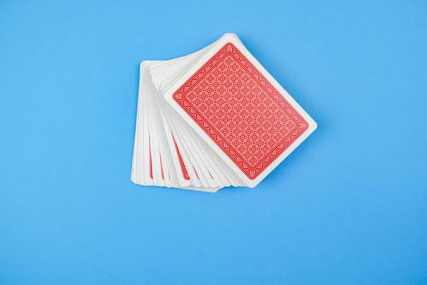 Mavi Arka Planda Bir Paket Kırmızı Kart Kumar Konsepti — Stok fotoğraf