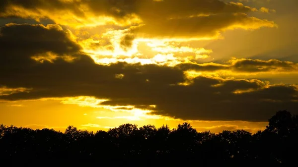 Die Sonne Geht Hinter Den Wolken Über Den Bäumen Unter — Stockfoto