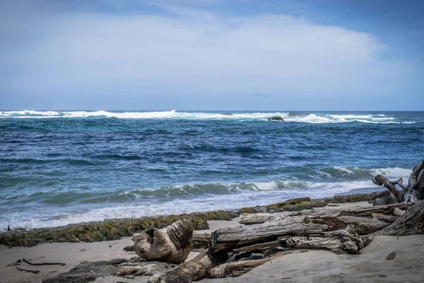 Güneşli Bir Günde Mavi Deniz Dalgalarına Karşı Kayalık Bir Sahilin — Stok fotoğraf