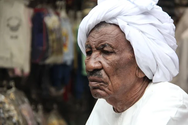 在埃及的一个市场上 一位身穿白色衣服的黑人老人凝视着远方 — 图库照片