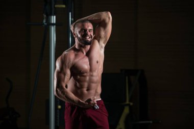 Spor salonundaki egzersizden sonra vücudunu gösteren çekici bir fitness modelinin portresi.