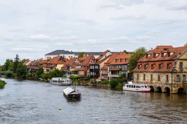 Almanya 'daki eski Bamberg kasabasının tarihi binalarıyla birlikte Regnitz Nehri' ndeki tekneler.