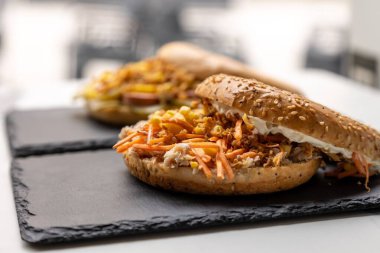 Etli ve diğer malzemeli bir simit sandviçi.