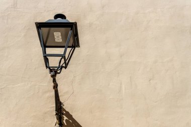 Bir evin bej duvarında açık hava siyah feneri.