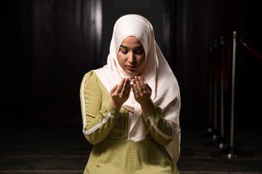 Camide huzur içinde dua eden muhteşem bir Müslüman kadının portresi.