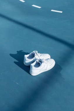 Basketbol sahasında beyaz Nike ayakkabılarının dikey çekimi..
