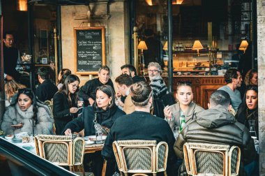 Paris, Fransa 'da bir kafenin önünde oturan insanlar.