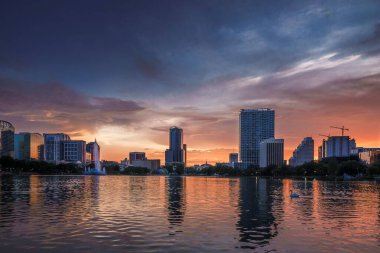 Ufukta gün batımı olan Orlando Florida Gölü Eola şehri.