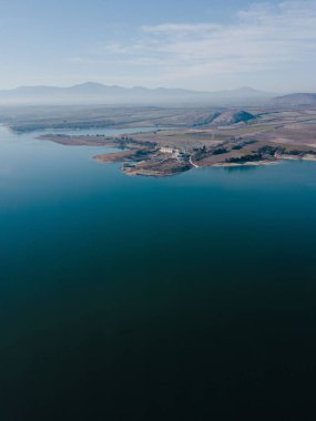 Sahilin arka tarafında güzel dağların göründüğü dikey bir hava görüntüsü.