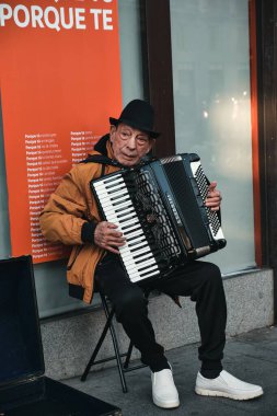Bir bankanın önünde akordeon çalan şehir sanatçısı