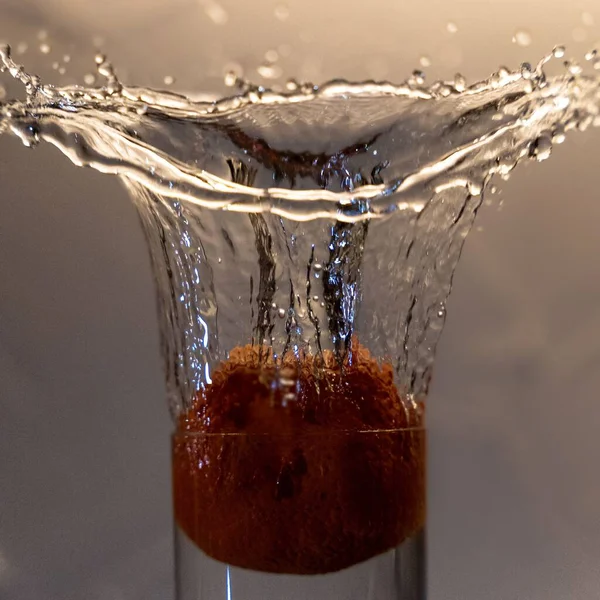 Una Naranja Cayendo Vaso Salpicando Agua —  Fotos de Stock