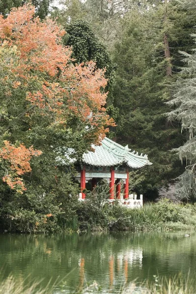 緑の木々と穏やかな水面に囲まれたサンフランシスコのストウ湖にある中国館の垂直方向の景色 — ストック写真