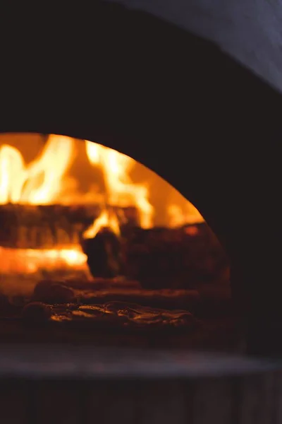 オーブンの火を背景にしたピザのクローズアップ — ストック写真