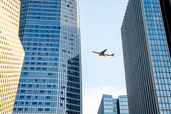 An airplane fly over modern office buildings in downtown