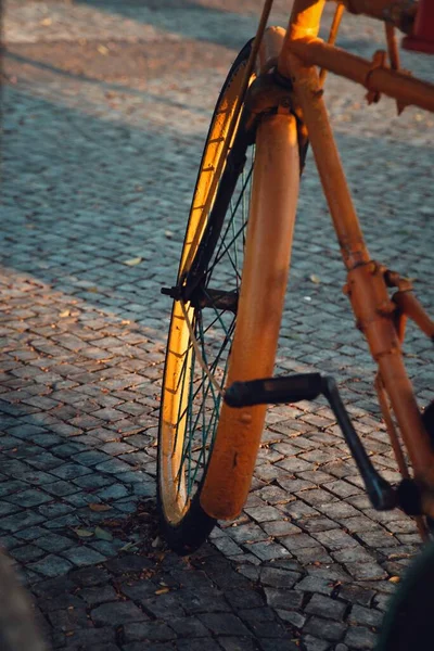 停在街上的一辆旧自行车的黄色轮子的垂直镜头 — 图库照片