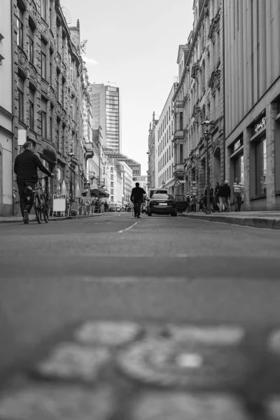 一个孤独的老人在大街中央行走时的垂直灰度 — 图库照片