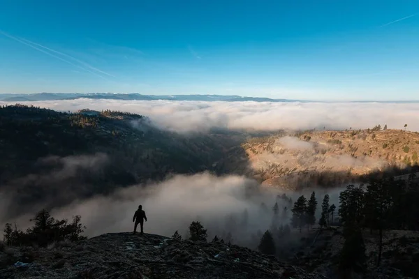 Wysoki Kąt Widzenia Gór Pokrytych Chmurami Człowiek Stojący Skale — Zdjęcie stockowe