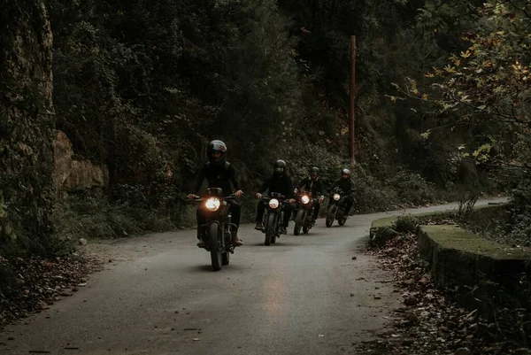一群令人敬畏的骑摩托车的人骑着摩托车穿过一片漆黑的森林 — 图库照片