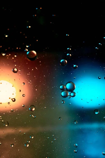 Μια Κάθετη Βροχή Σταγονίδια Στο Γυαλί Μπλε Και Πορτοκαλί Φώτα — Φωτογραφία Αρχείου
