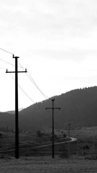 Una Scala Grigi Campi Con Linee Elettriche Stazioni Intorno Montagne — Foto Stock