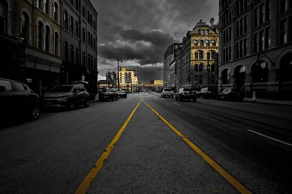 威斯康星州密尔沃基的一条空荡荡的街道 街道上有明亮的黄色线条 周围是漆黑天空下的建筑物 — 图库照片
