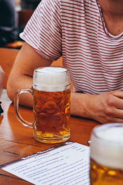 Eine Vertikale Aufnahme Eines Bierglasbechers Auf Einem Tisch Und Jemand — Stockfoto