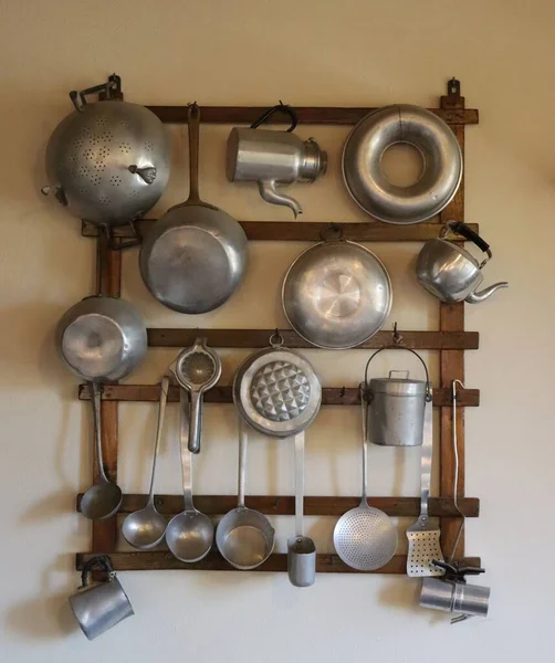Vertikální Záběr Starých Hliníkových Kuchyňských Potřeb Zavěšených Dřevěném Ramínku Stěně — Stock fotografie