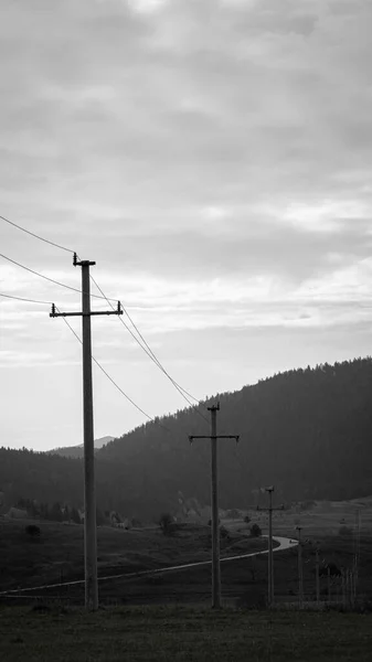 Eine Graustufe Von Feldern Mit Stromleitungen Und Stationen Ringsum Bergen — Stockfoto
