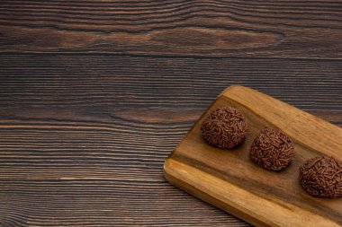 Çikolatalı Brezilya Brigadeiro 'nun fotokopi alanı olan kesme tahtasındaki yakın çekimi.