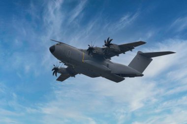 Mavi gökyüzünde uçan bir Airbus A400M Atlas askeri nakliye uçağı.