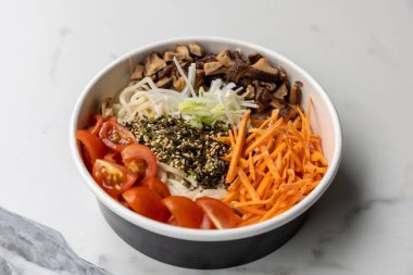 Beyaz arka planda farklı malzemelerle dolu bir kase.