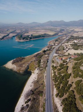 Sahilin arka tarafında güzel dağların göründüğü dikey bir hava görüntüsü.