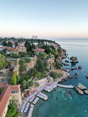 Türkiye 'nin Antalya kentinde güneş doğarken güzel bir plaj sandalyesi ve tatil köyü manzarası